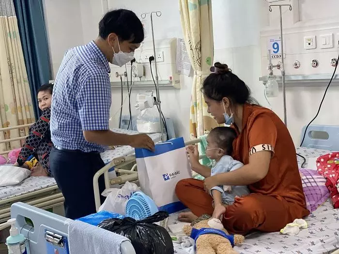 Tình nguyện viên phát quà Trung Thu tại giường bệnh cho các bé.